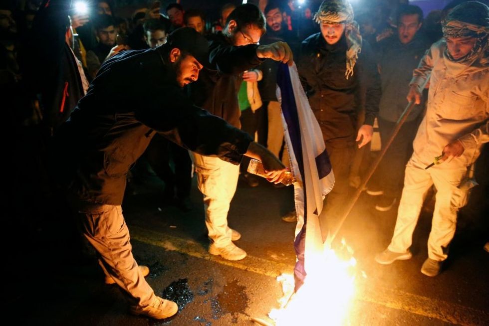 Masked campaigners were spotted setting off explosives and burning Israeli and American flags