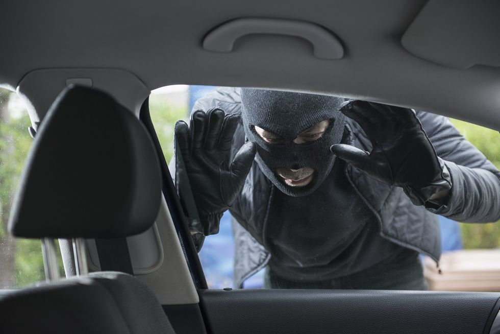 Masked man looking into car