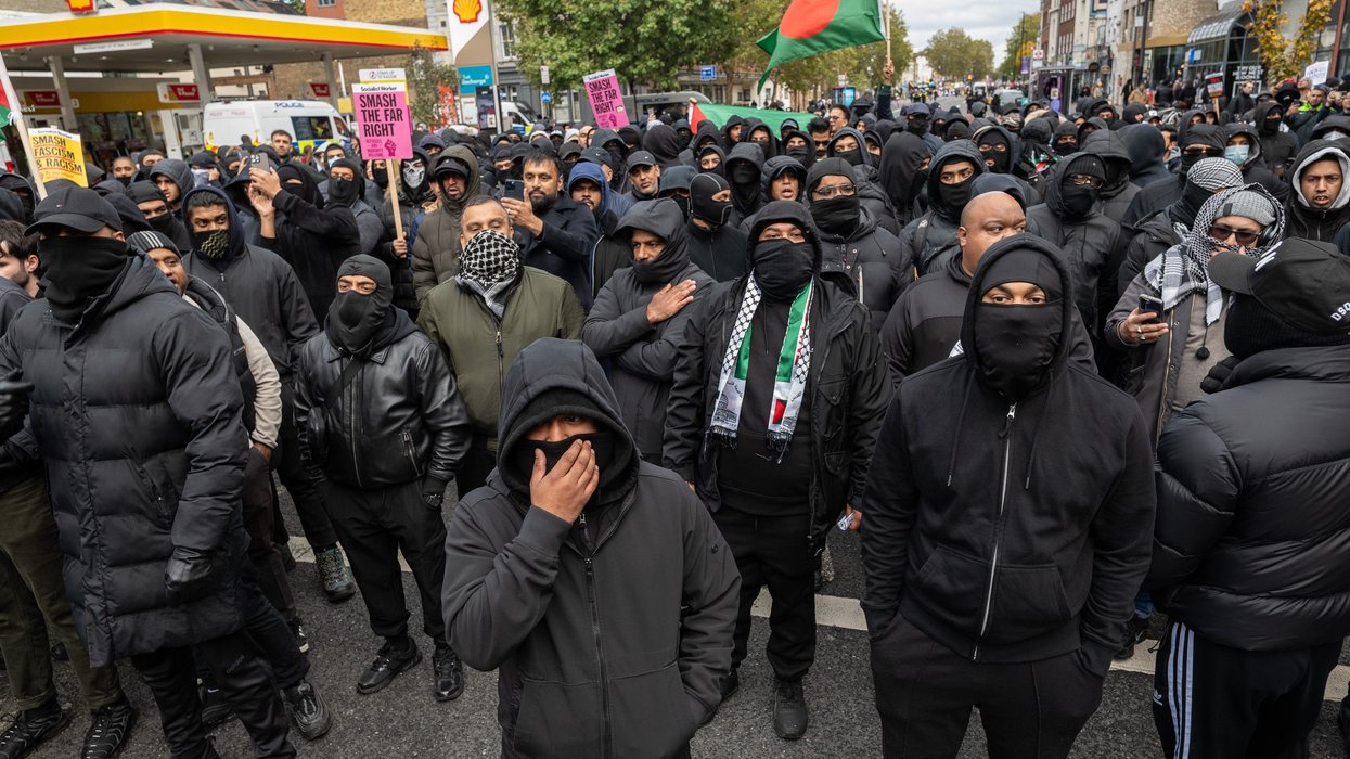 Masked men march through Whitechapel, Tower Hamlets - with one waving a Bangladeshi flag