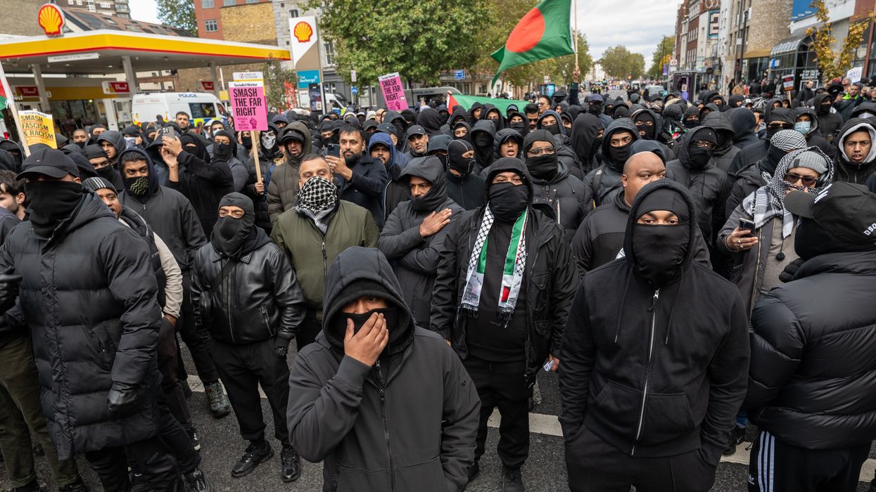 Masked men march through Whitechapel, Tower Hamlets - with one waving a Bangladeshi flag