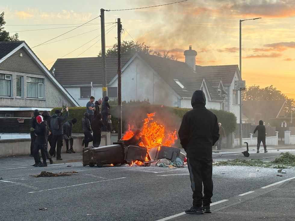 Masked men surround a bin fire in Northern Ireland protest