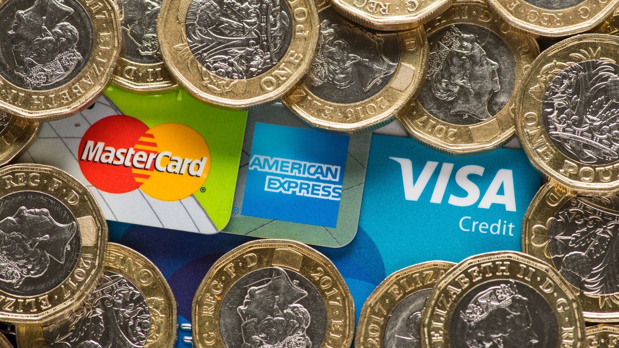 Mastercard, American Express and Visa credit cards with UK one pound coins