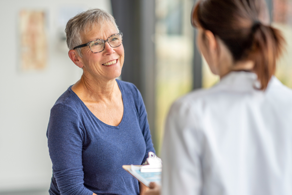 Mature patient smiling while speaking with a doctor