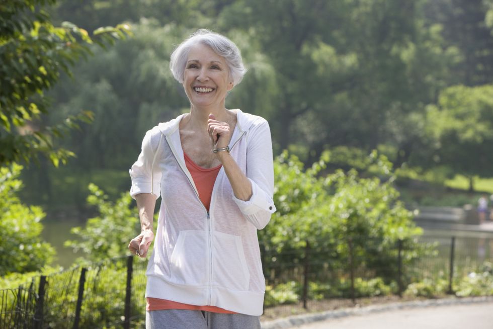 Mature smiling woman with grey hair going for a brisk walk