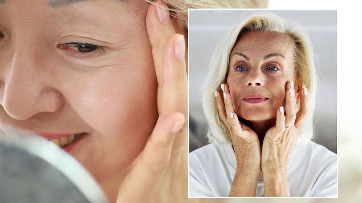 Mature woman checking lines around eyes / Mature woman examining face in mirror