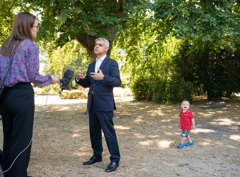 Maxwell Tall, 2, cries as Mayor of London Sadiq Khan speaks to the media