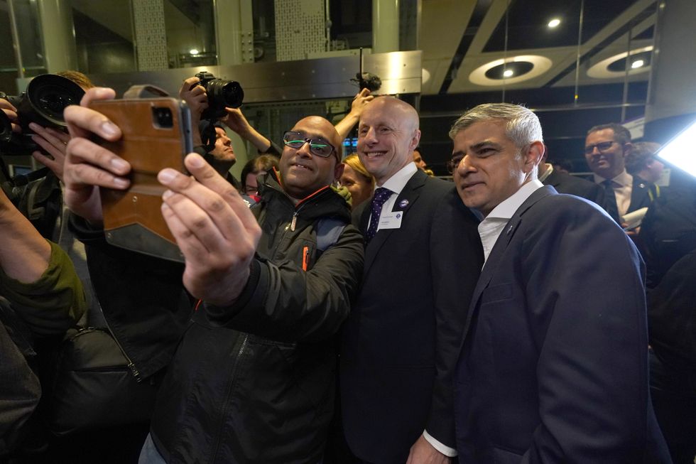 Mayor of London Sadiq Khan (right) and Andy Byford, Commissioner at Transport for London (Tfl) (centre) pose for a selfie as they wait on the platform to board the first Elizabeth line train