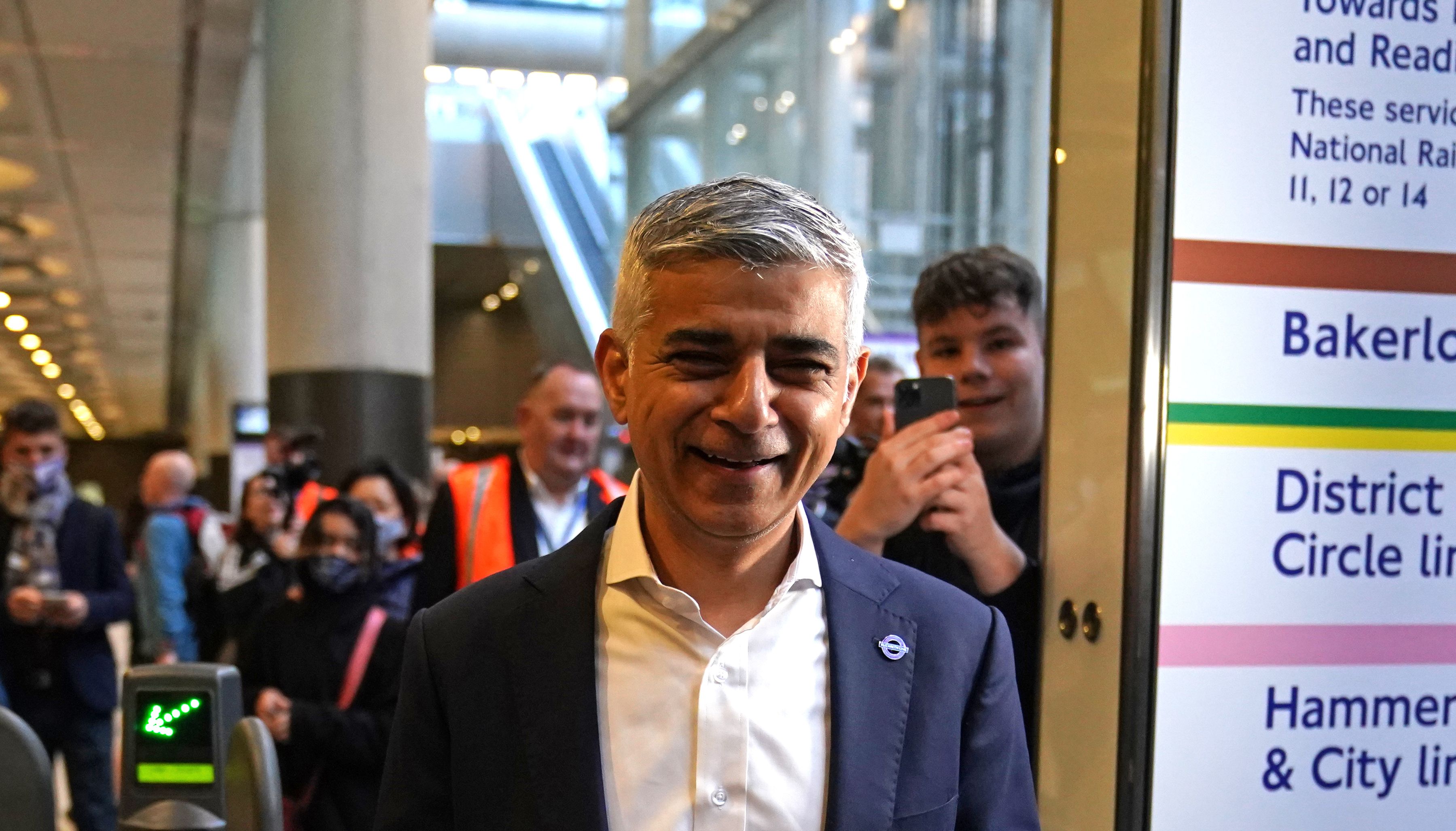 Mayor of London Sadiq Khan taps his Oyster card as he goes through the barriers toward the platform