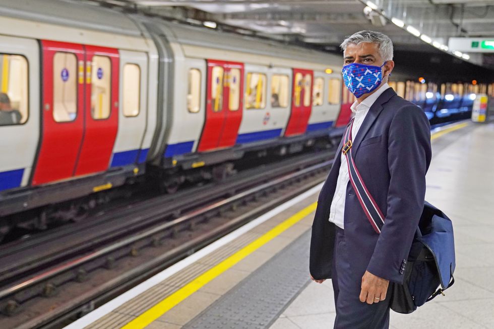 Mayor of London Sadiq Khan wears a mask as he waits on a platform at Westminster Station to catch a train on the Underground to visit the London Transport Museum.