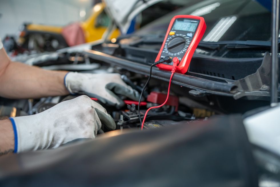 Mechanic checking the voltage of a car battery