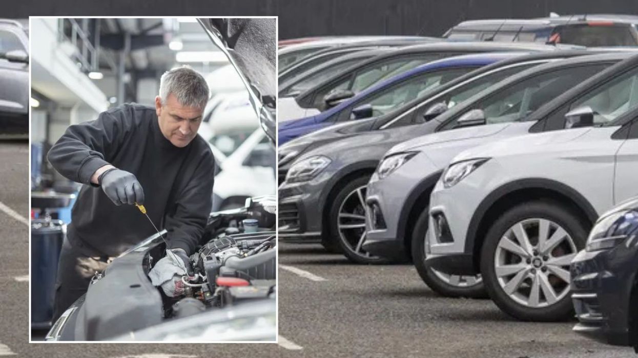 Mechanic conducting an MOT test and parked cars
