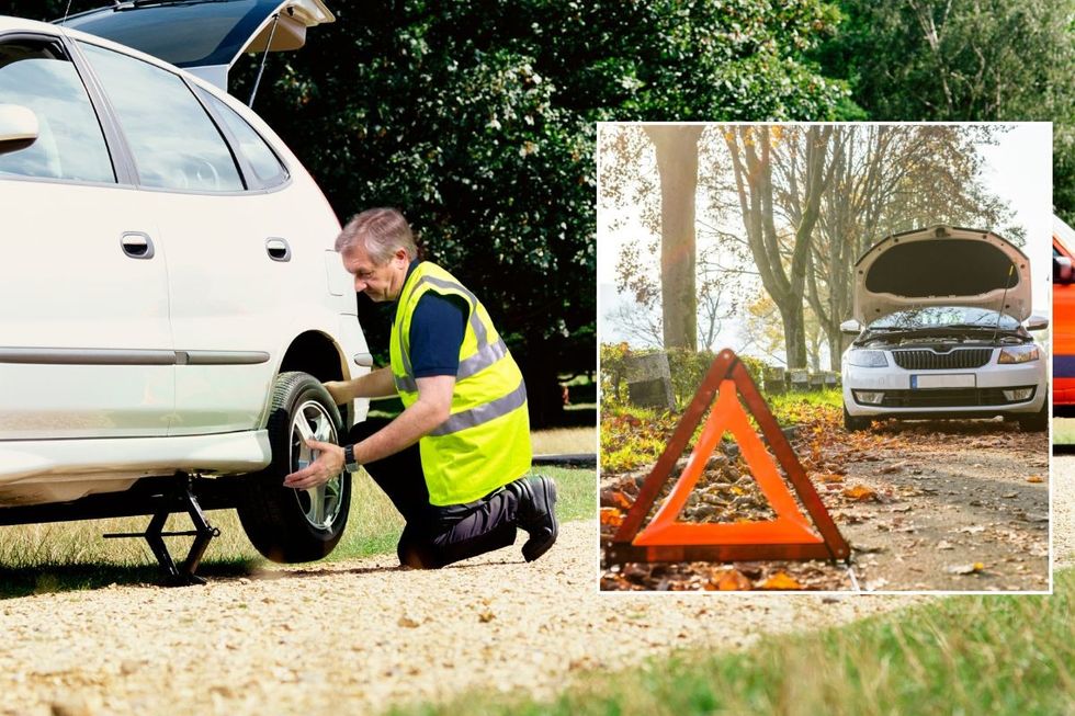 Mechanic fixing a car wheel and a broken down vehicle with an orange warning triangle on the road