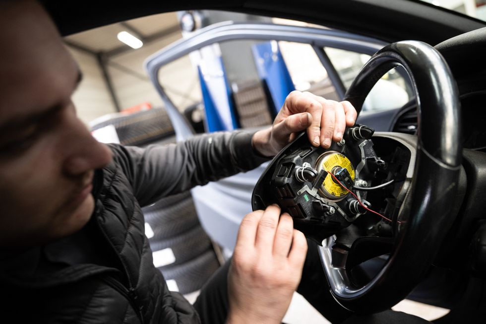 Mechanic replacing a faulty Takata airbag in France