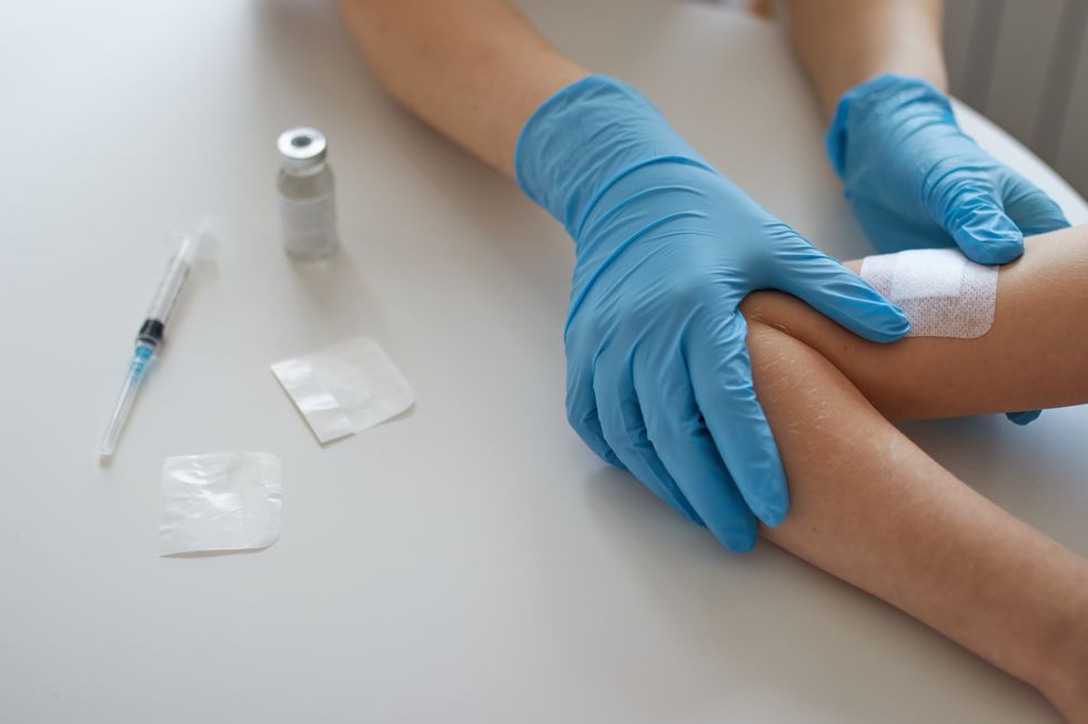 Medic putting a plaster after giving a vaccine