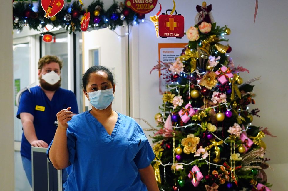 Medical staff walk past a Christmas tree on a ward for Covid patients at King's College Hospital, in south east London.