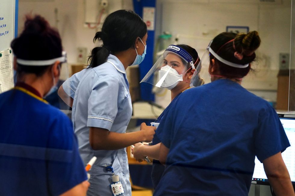 Medical staff wearing PPE on a ward for Covid patients at King's College Hospital, in south east London. Picture date: Tuesday December 21, 2021.