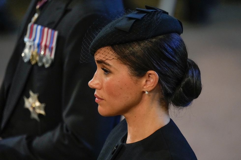 Meghan, Duchess of Sussex stands in Westminster Hall after participating in the procession of the coffin of Queen Elizabeth, London, Wednesday, Sept. 14, 2022. The Queen will lie in state in Westminster Hall for four full days before her funeral on Monday Sept. 19. Gregorio Borgia/Pool via REUTERS