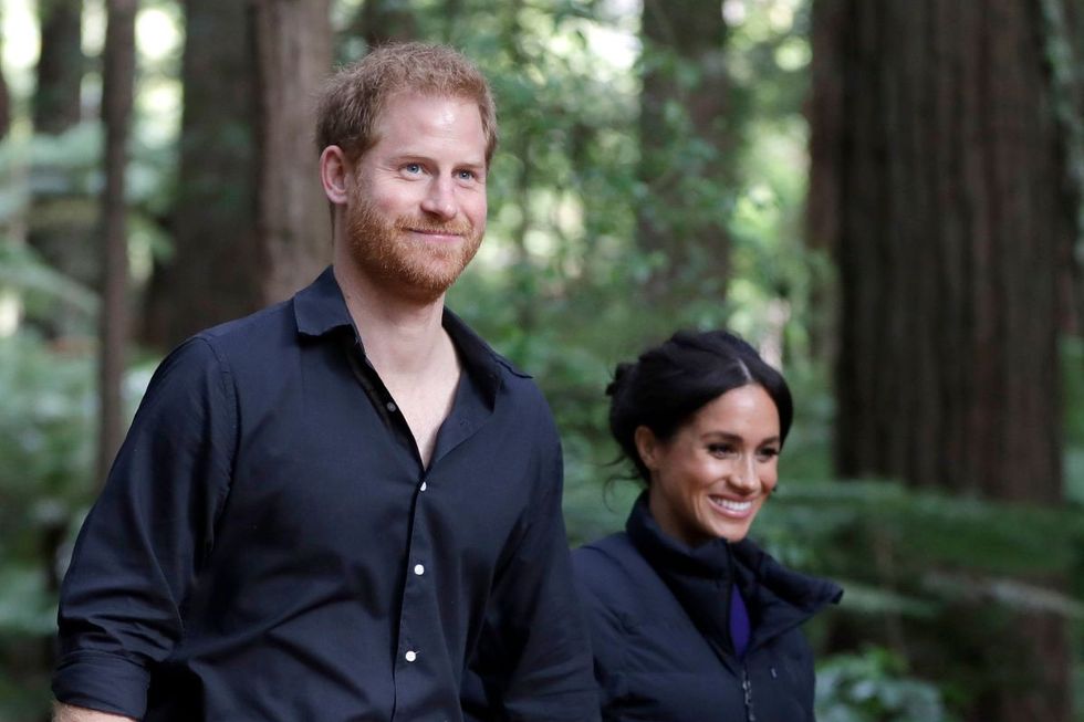 Meghan Markle and Prince Harry walking in a forest