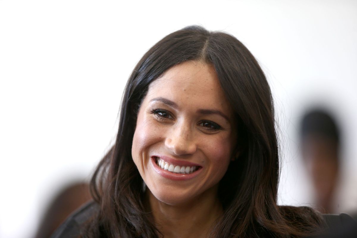Meghan Markle smiles as she attends a reception with delegates from the Commonwealth Youth Forum at the Queen Elizabeth II Conference Centre
