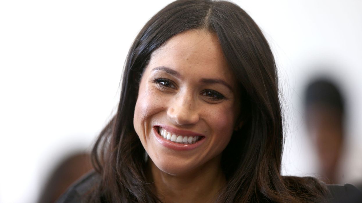 Meghan Markle smiles as she attends a reception with delegates from the Commonwealth Youth Forum at the Queen Elizabeth II Conference Centre
