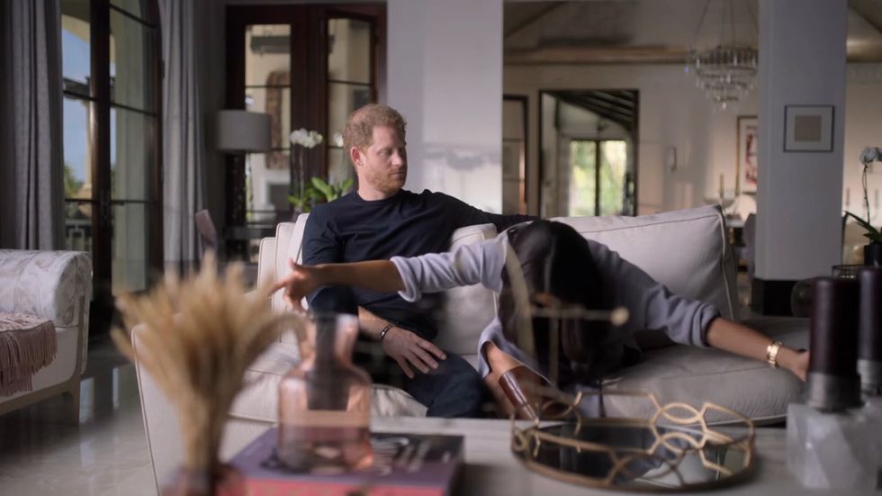 Meghan put her arms out wide and bowed her head down low as she recounted how she tried to greet the late monarch when they first met.