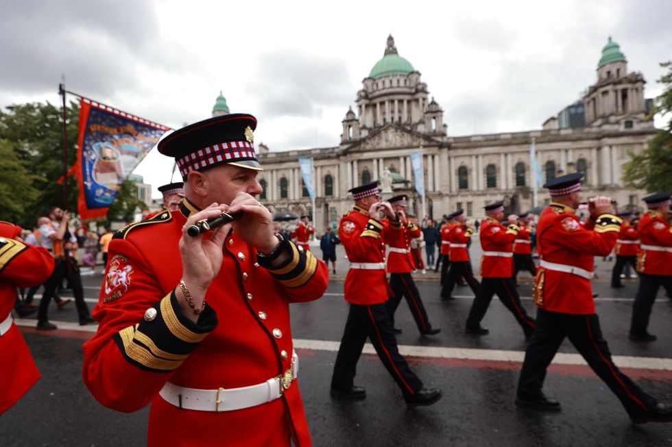 Members of a flute band pass Belfast City Hall