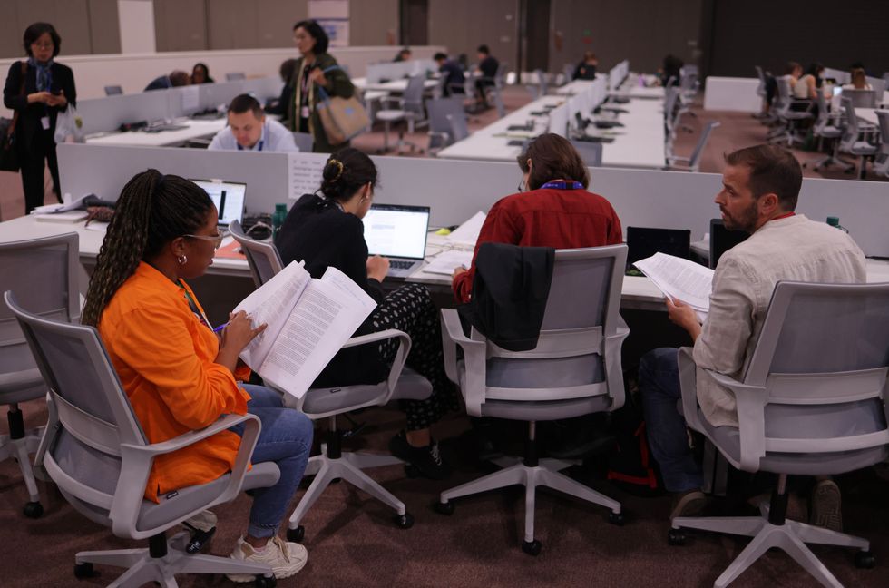Members of a Spanish environmental NGO look over the "Draft text by the President" of the "First global stocktake under the Paris Agreement"