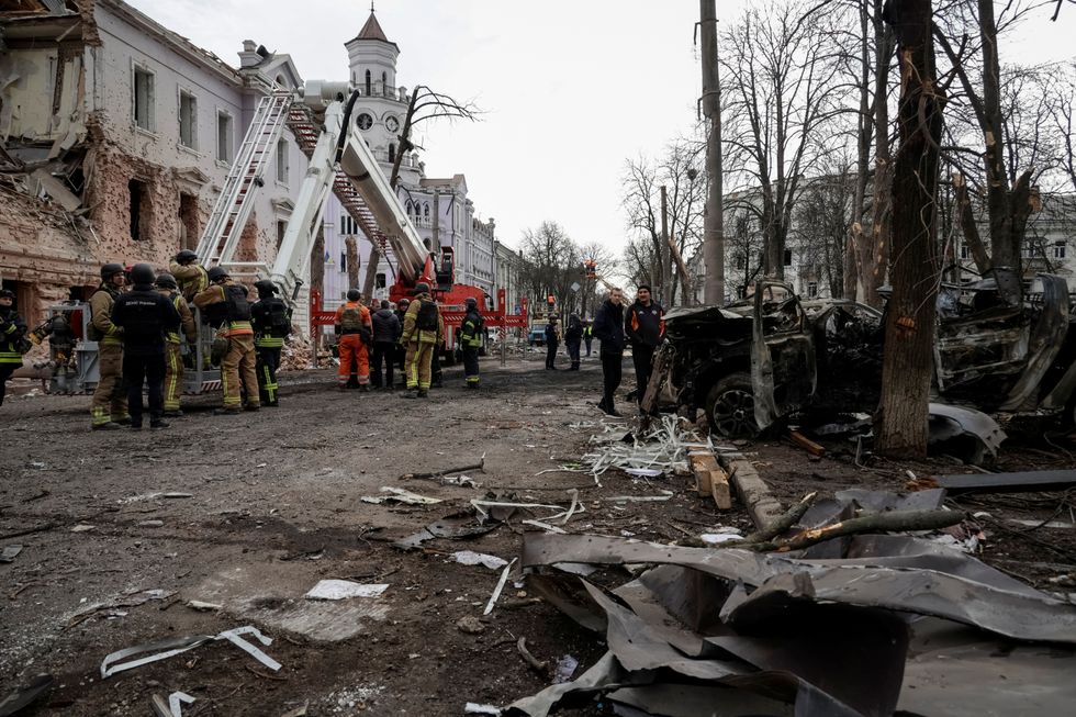 Members of emergency services work at the site of a Russian missile strike