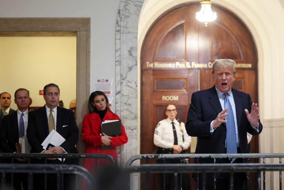 Members of former U.S. President Donald Trump's legal team look on as he delivers remarks