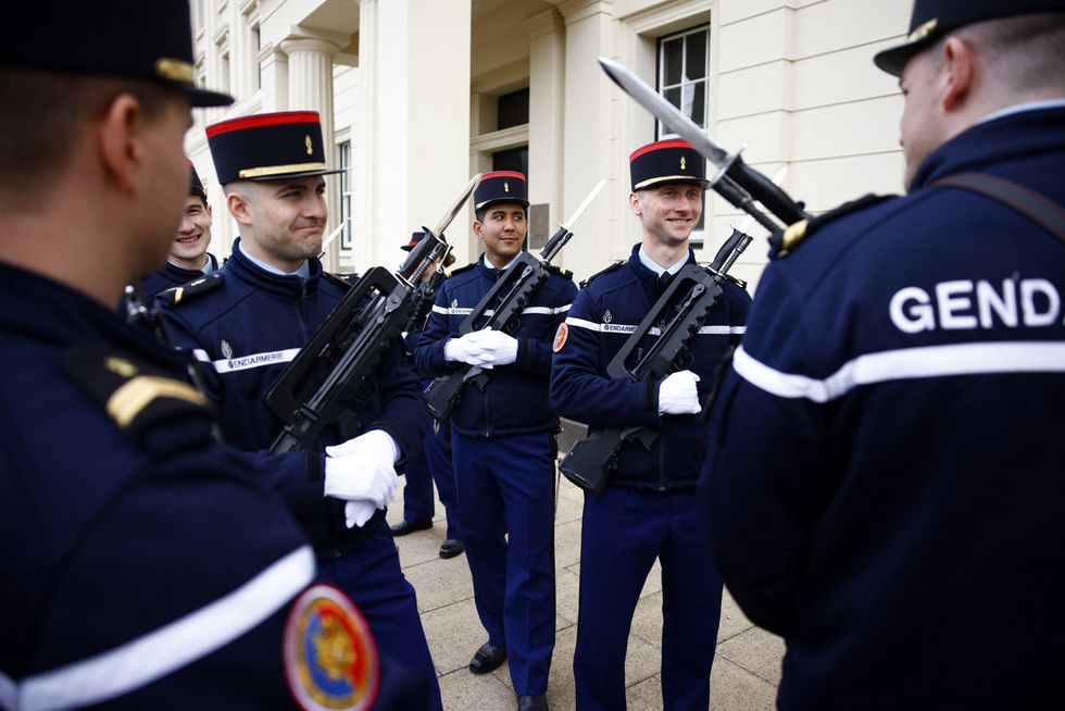 Members of France's Gendarmerie Garde Republicaine react after taking part in a rehearsal for a special Changing of the Guard ceremony, at Wellington Barracks