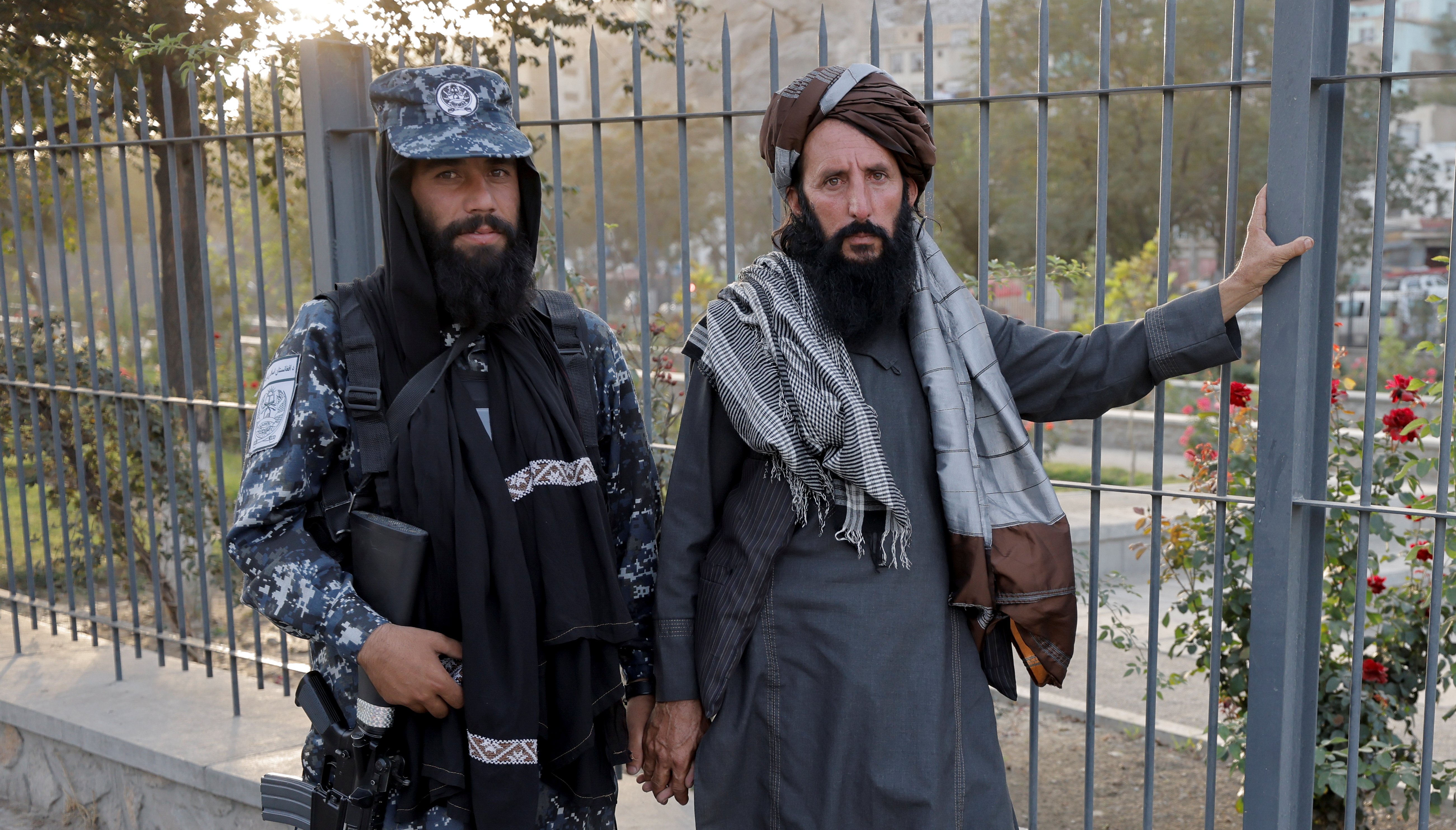 Members of Taliban forces, of which one is armed, pose at a check point after several civilians were killed in an explosion, in Kabul.