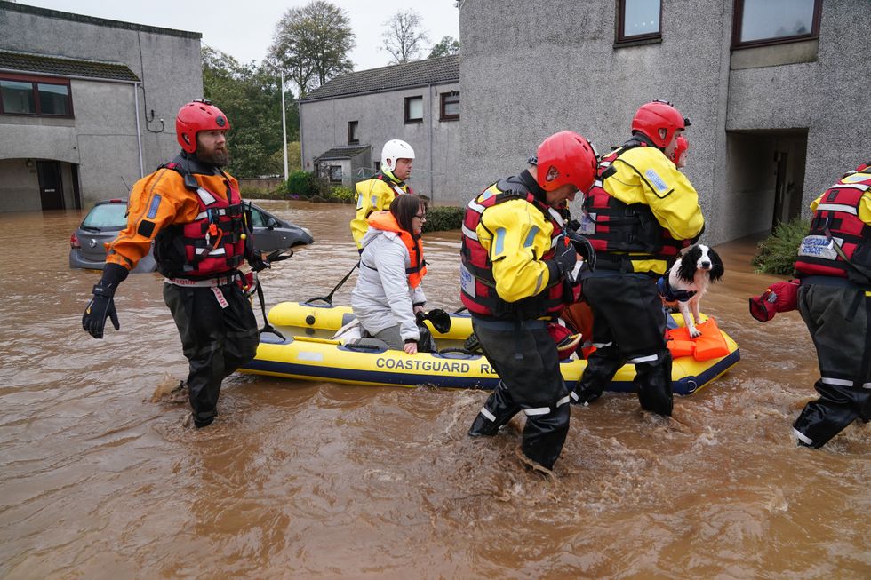 Members of the emergency services help local residents to safety in Brechin, Scotland