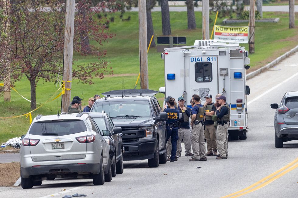 Members of the FBI Evidence Response Team and State Police gather at the site of a mass shooting at Schemengees Bar and Grille