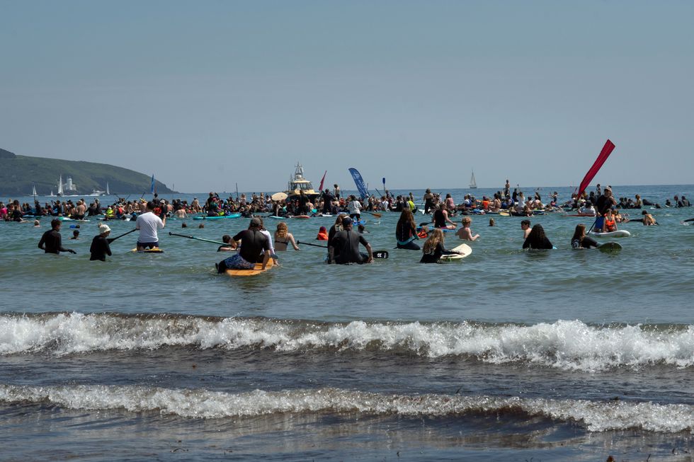 Members of the public attend a paddle-out protest organised by environmental campaign group Surfers Against Sewage at Gyllngvase beach in Falmouth, Cornwall
