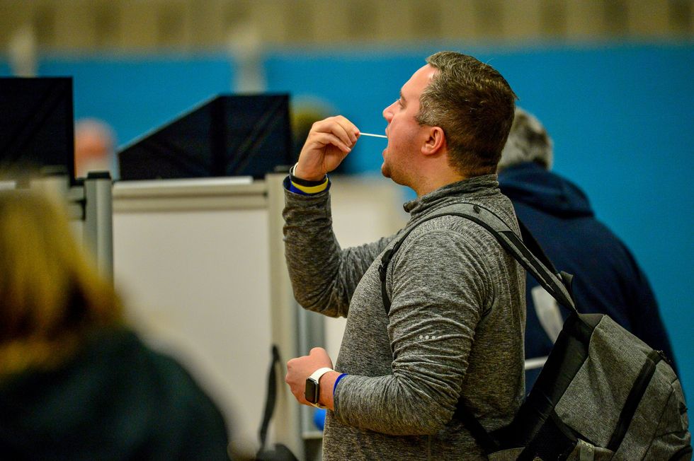 Members of the public complete a test swab during a lateral flow Covid test at Rhydycar leisure centre in Merthyr Tydfil, where mass coronavirus testing begins following a two-week %22firebreak%22 lockdown.