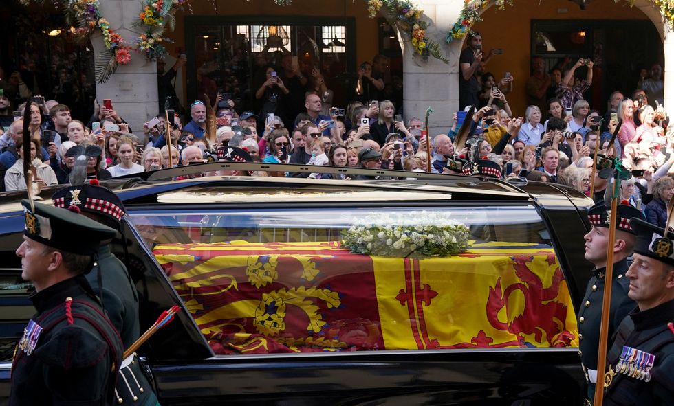 Members of the public look on a Queen Elizabeth II's coffin makes its way from the Palace of Holyroodhouse to St Giles' Cathedral, Edinburgh. Picture date: Monday September 12, 2022.