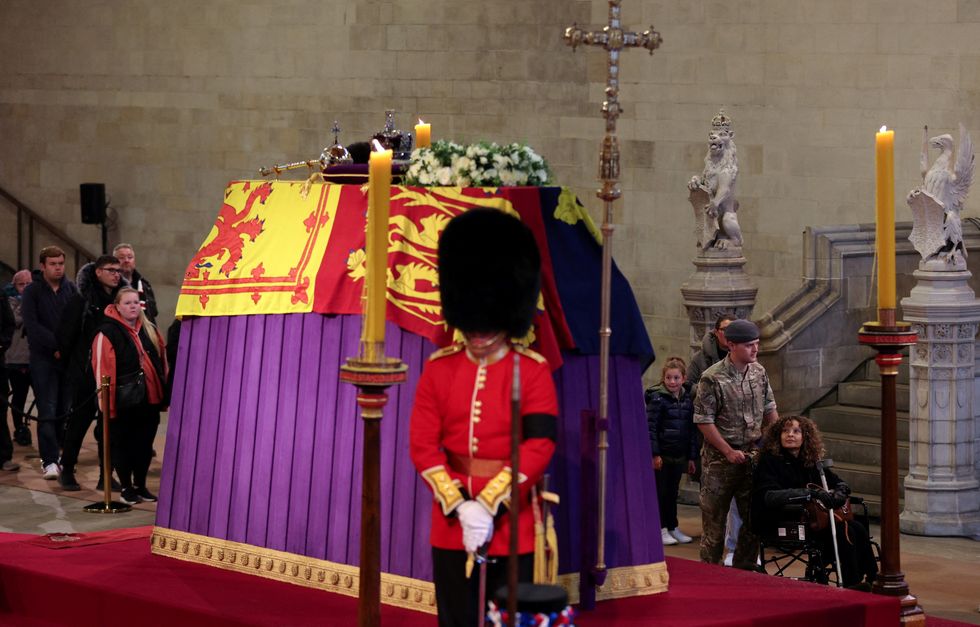 Members of the public pay their respects as they pass the coffin of Queen Elizabeth II, Lying in State inside Westminster Hall, at the Palace of Westminster in London on September 18, 2022. - Britain was gearing up Sunday for the momentous state funeral of Queen Elizabeth II as King Charles III prepared to host world leaders and as mourners queued for the final 24 hours left to view her coffin, lying in state in Westminster Hall at the Palace of Westminster. PAUL ELLIS/Pool via REUTERS