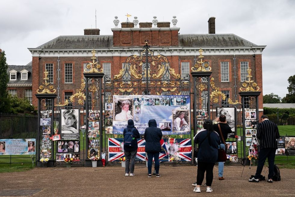 Members of the public seen outside the gates of Kensington Palace, central London, on the 26th anniversary of the death of Diana