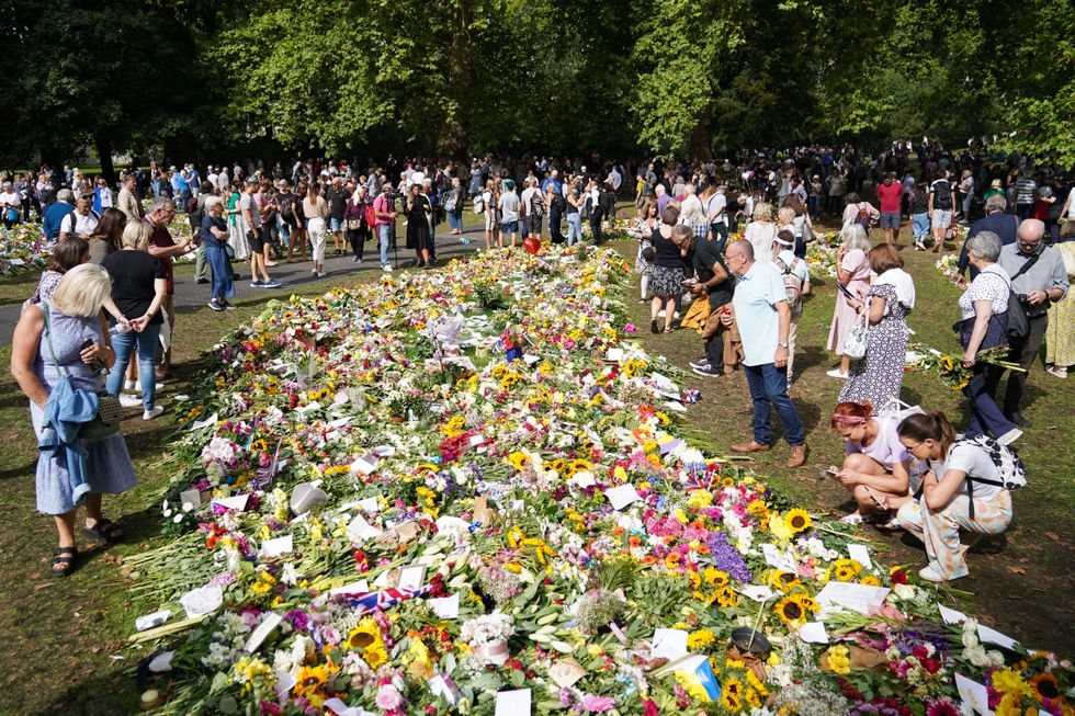 Members of the public view floral tributes in Green Park, near Buckingham Palace, London following the death of Queen Elizabeth II on Thursday. Picture date: Monday September 12, 2022.