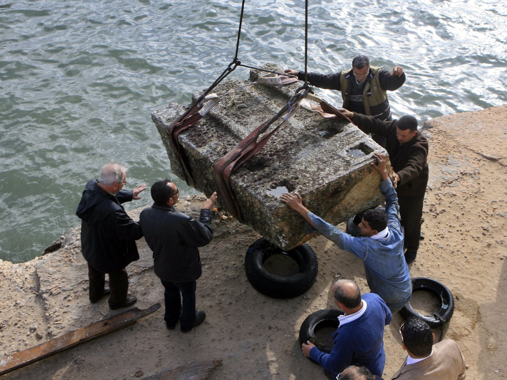 Men lifting artefact from the sea in Egypt