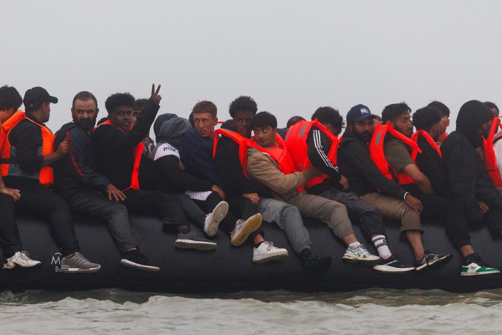 MEN SITTING ON A SMALL BOAT ON THE CHANNEL