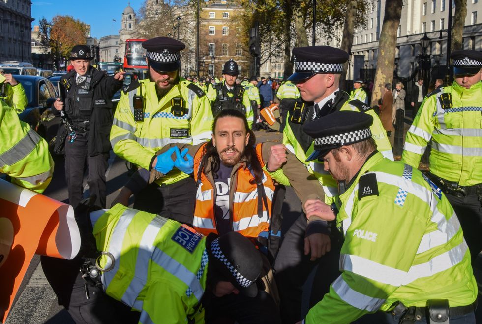 Metropolitan Police officers arrest a Just Stop Oil activist during the demonstration in Whitehall outside Downing Street