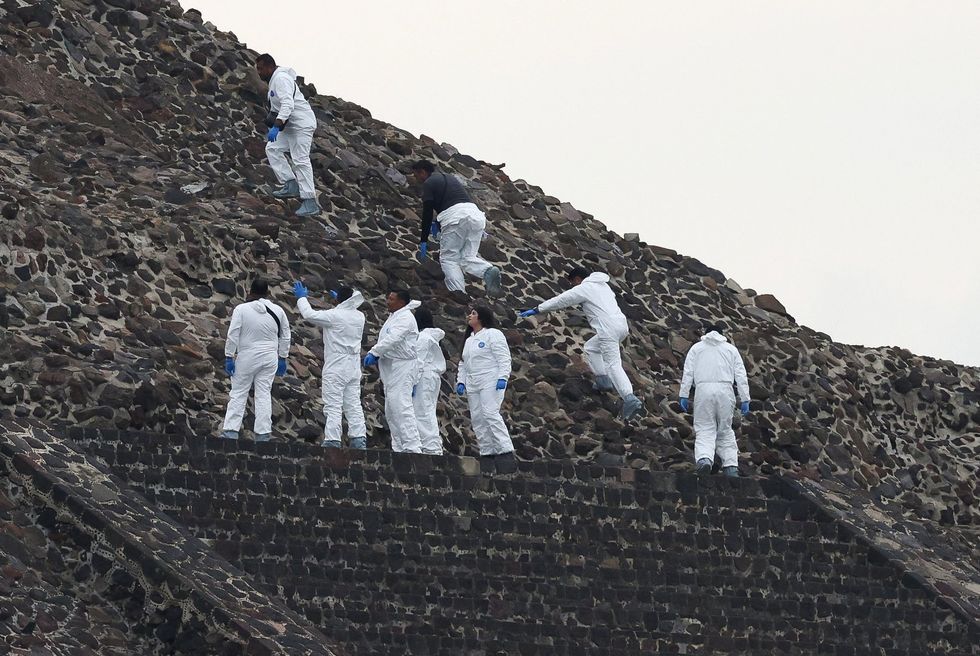 Mexican authorities work on the Pyramid of the Moon at the scene where a man shot dead a Canadian woman and injured several others before killing himself