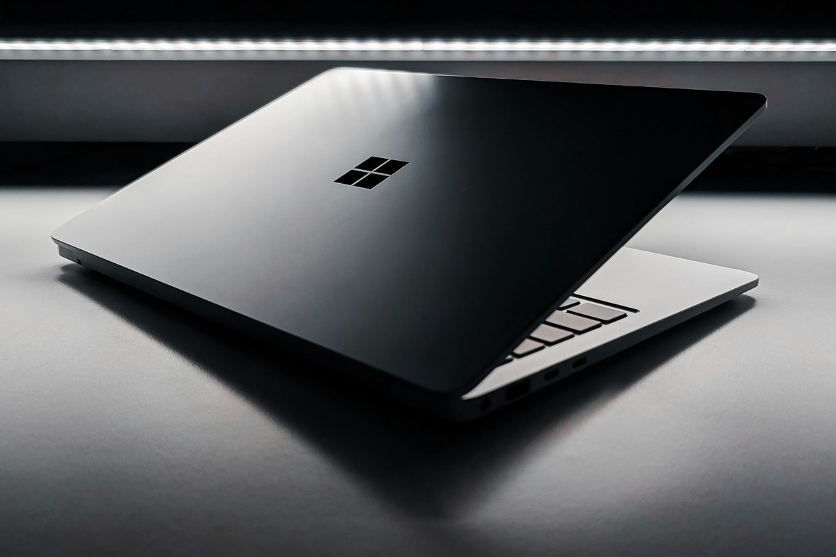 microsoft windows logo etched on the back of a silver aluminium laptop