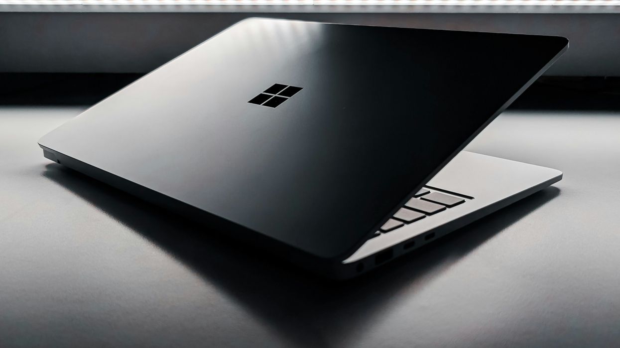 microsoft windows logo etched on the back of a silver aluminium laptop