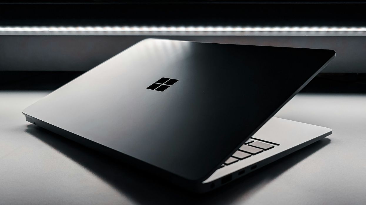 microsoft windows logo etched on the back of a silver aluminium laptop