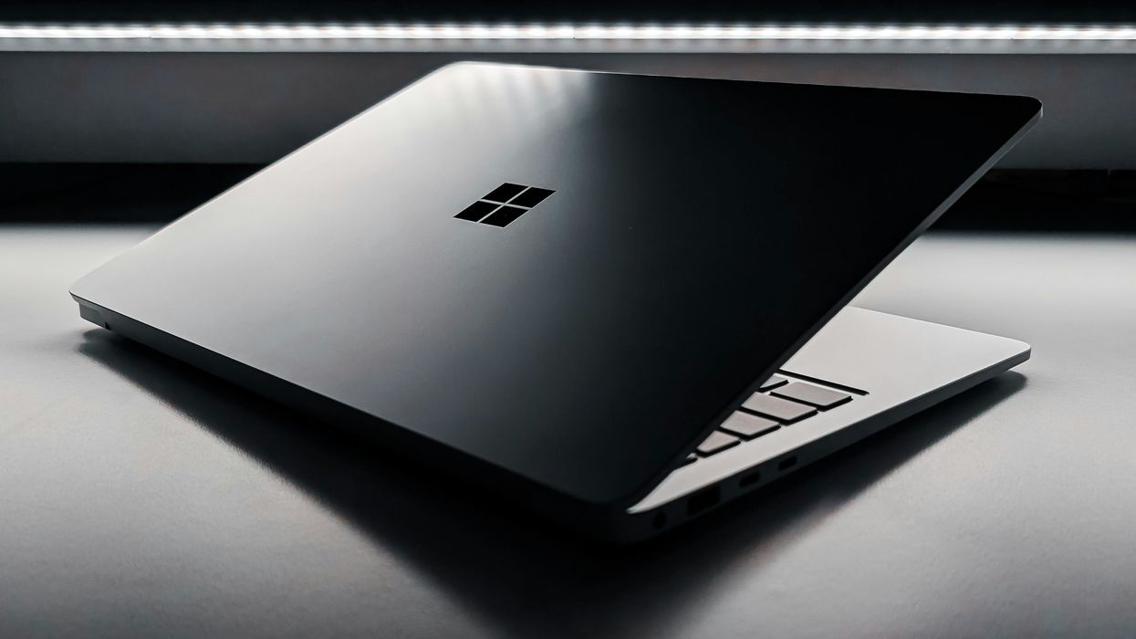 microsoft windows logo etched on the back of a silver aluminium laptop