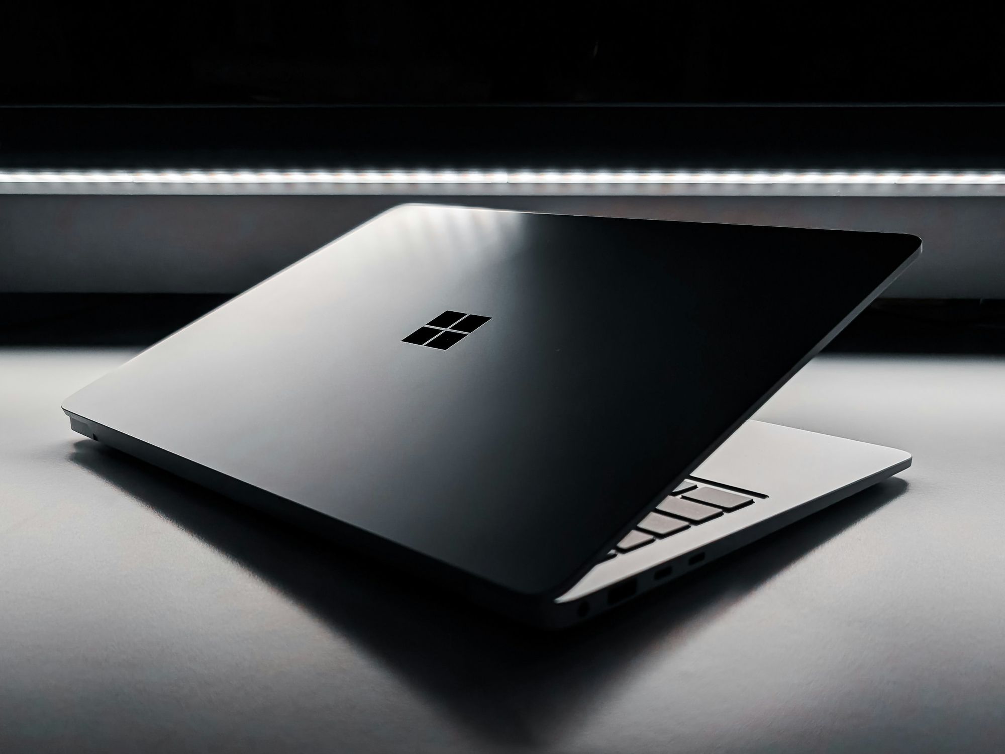 microsoft windows logo etched on the back of a silver aluminium laptop