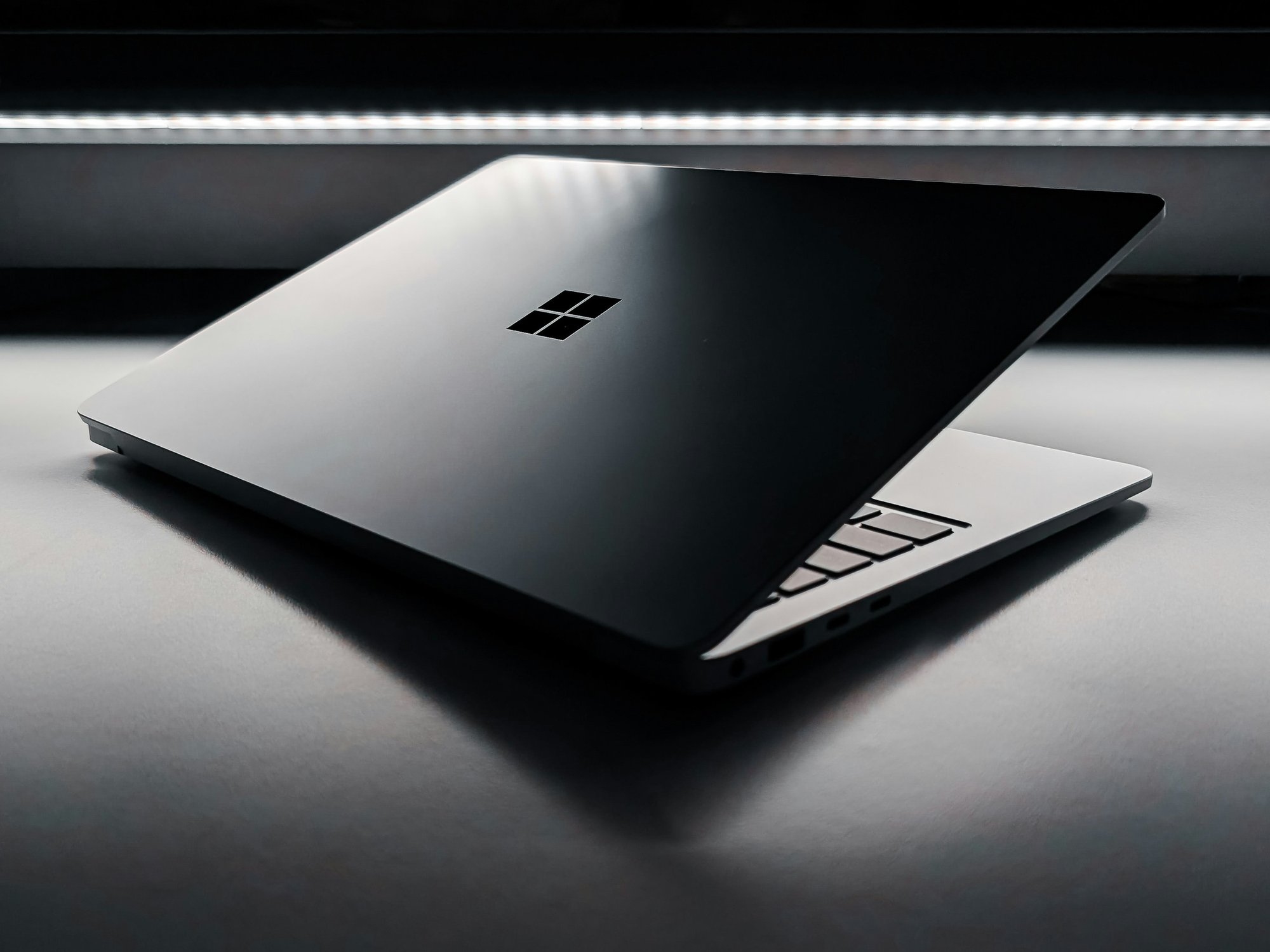 microsoft windows logo etched on the back of a silver aluminium laptop