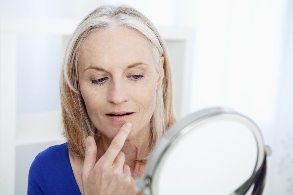 Middle age woman looking in mirror